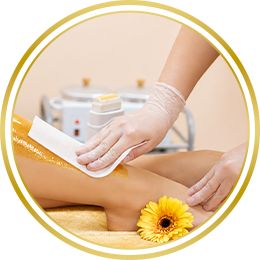 Circular image of a hand receiving a waxing or skincare treatment
